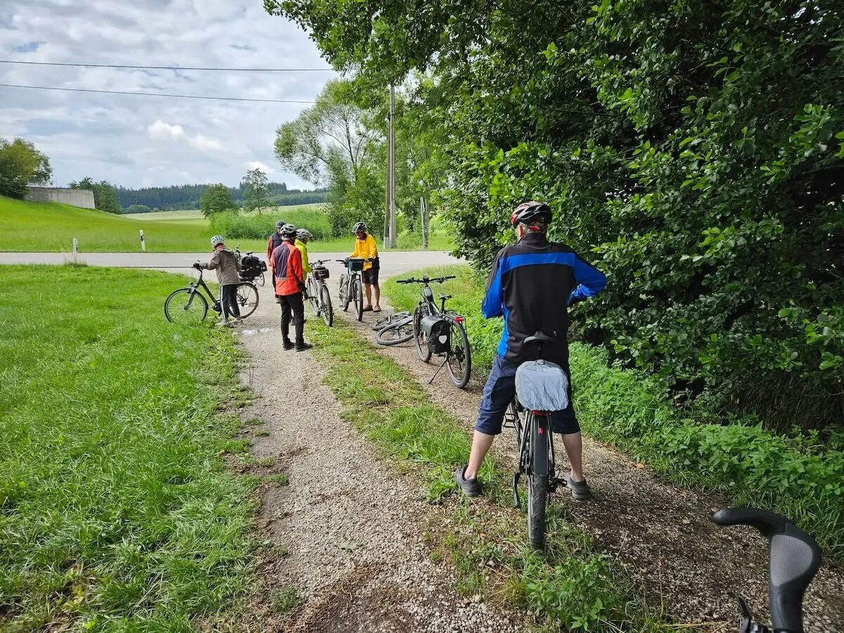 Sechs ältere Radfahrer machen Pause auf einem Landweg – Helme, Gepäcktaschen und Natur prägen das ländliche Tourenbild. | © DAV Markt Schwaben | Seniorengruppe