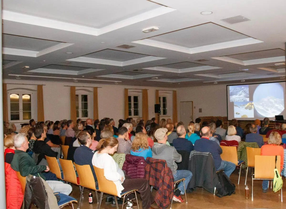 Besucher:innen der Multivisionsshow verfolgen den Vortrag auf der Bühne in Markt Schwaben | © DAV Markt Schwaben