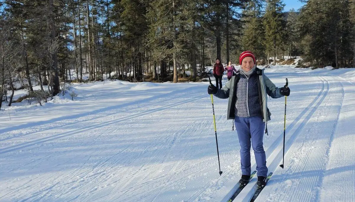 Eine Person läuft auf frisch gespurter Loipe durch verschneiten Wald. Weitere Teilnehmende folgen auf der Kanada-Loipe im Isartal. | © DAV Markt Schwaben/Lutz Gründel