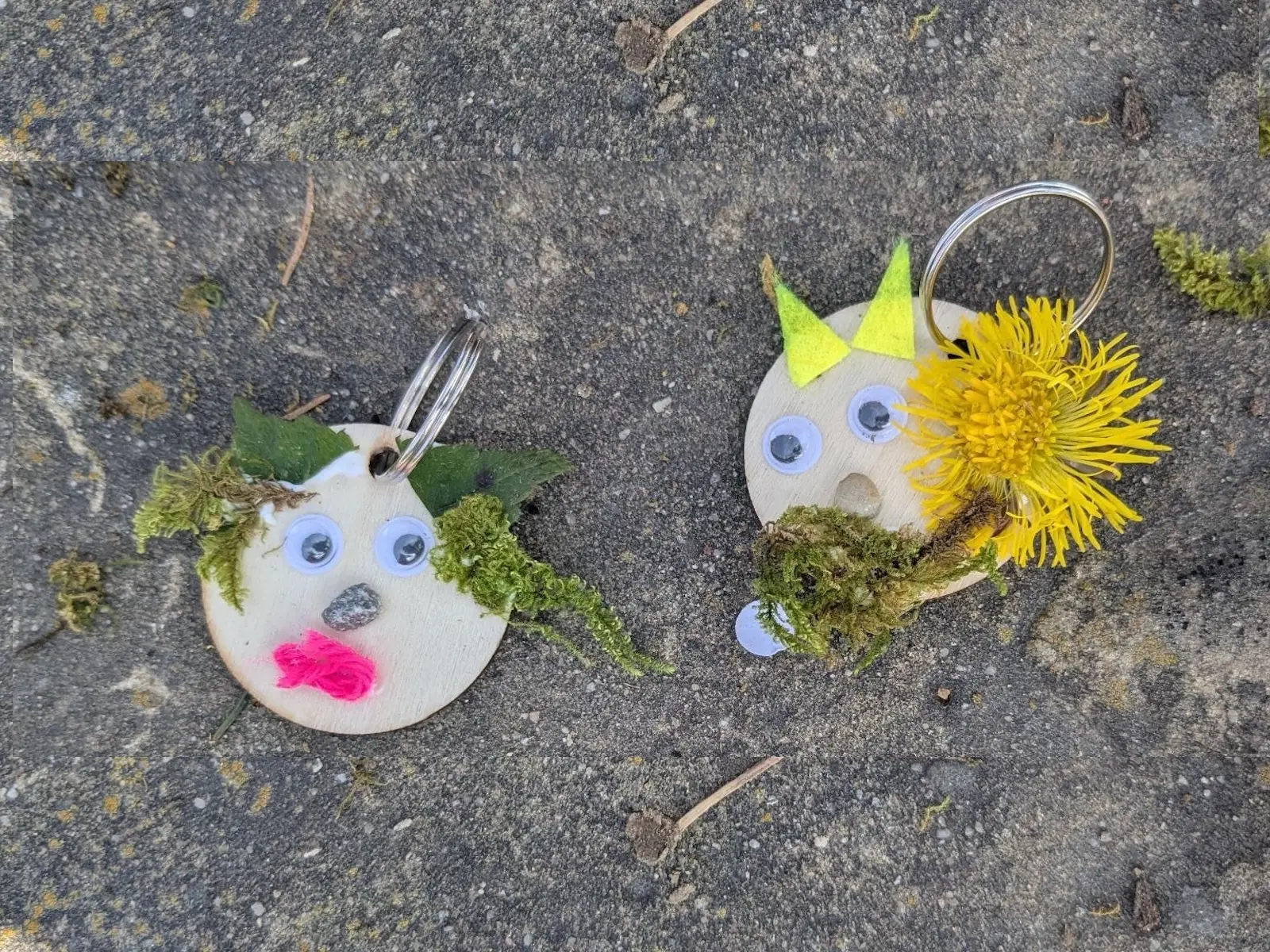 Zwei runde Holzanhänger liegen auf grauem Untergrund und zeigen mit Naturmaterialien gestaltete Trollgesichter mit Moos, Augen und Blüten. | © DAV Markt Schwaben/Silke Titze