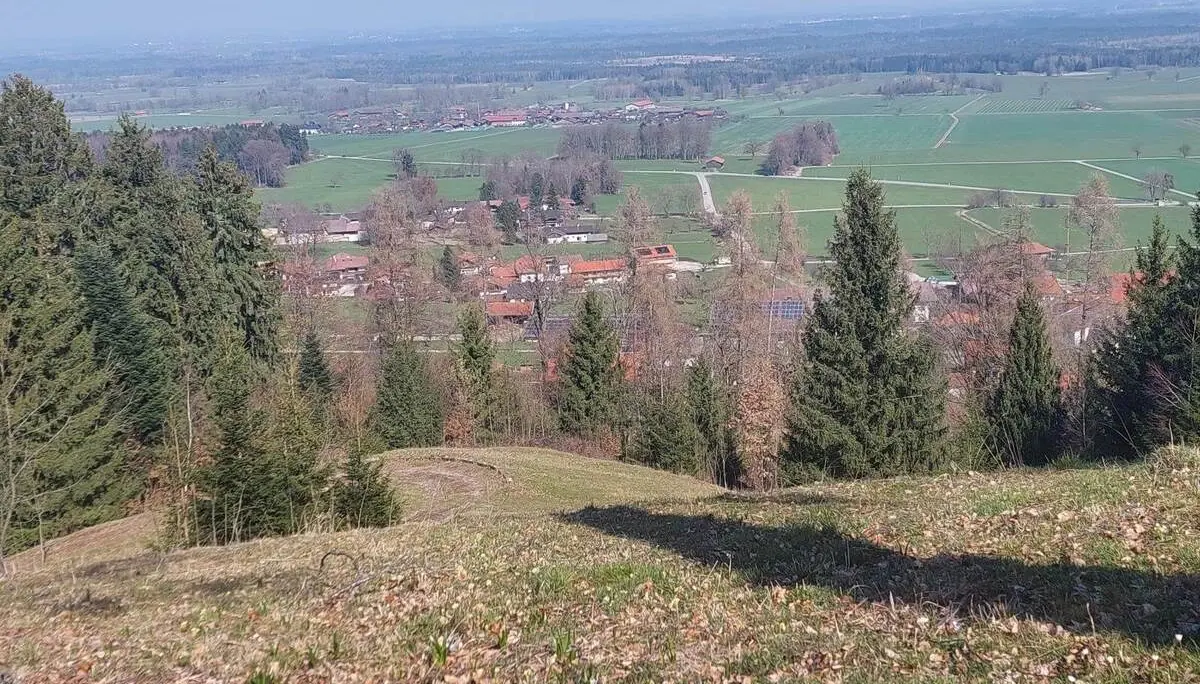 Blick von einer Anhöhe über einen Ort mit roten Dächern, umgeben von Wiesen und Wäldern im Voralpenland bei Bad Feilnbach. | © DAV Markt Schwaben