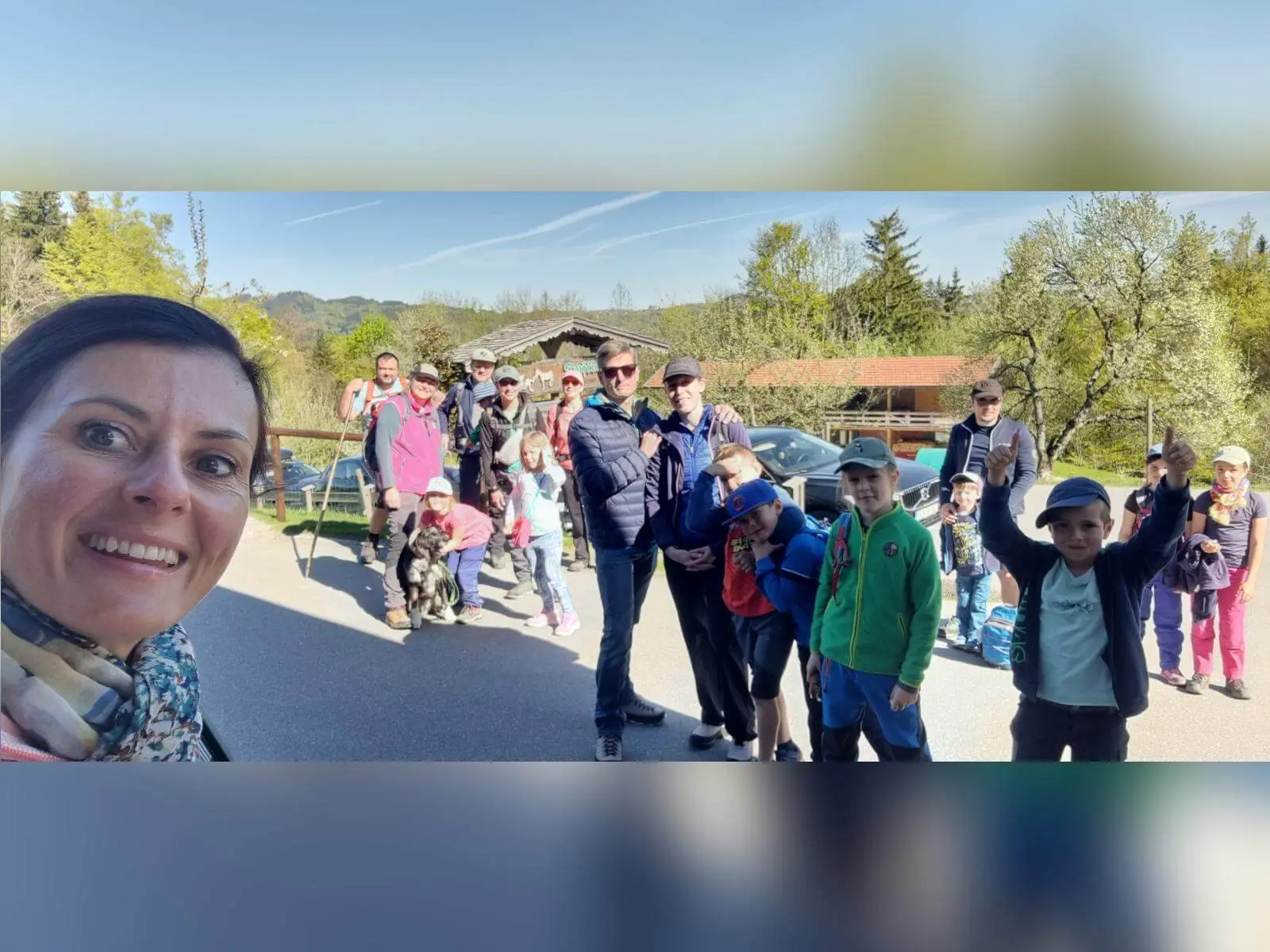Familiengruppe mit Kindern steht am Parkplatz vor Wanderstart; Erwachsene und Kinder tragen Rucksäcke, ein Hund sitzt dabei. | © DAV Markt Schwaben/Maria Wenisch