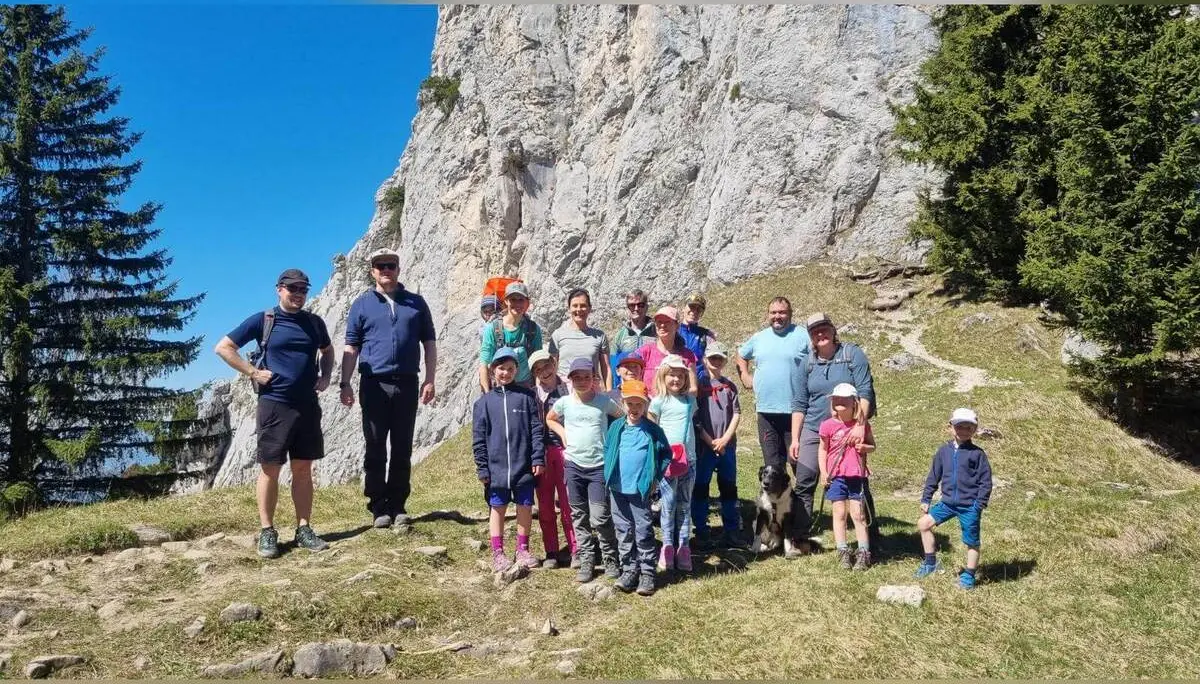 Familiengruppe mit Kindern steht auf einer Wiese vor steiler Felswand der Wasserwand; alle versammelt nach der Tour. | © DAV Markt Schwaben/Maria Wenisch