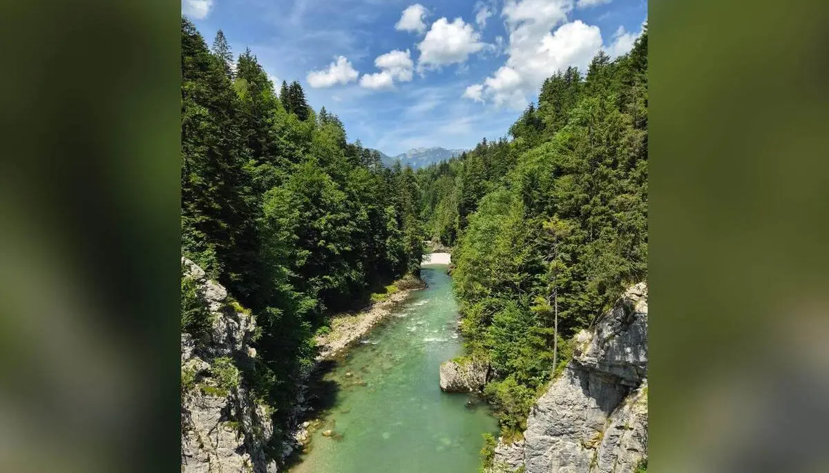 Blick entlang der türkisgrünen Tiroler Ache zwischen steilen Felswänden und dicht bewaldeten Hängen unter blauem Himmel. | © DAV Markt Schwaben / Hubert Inhofer