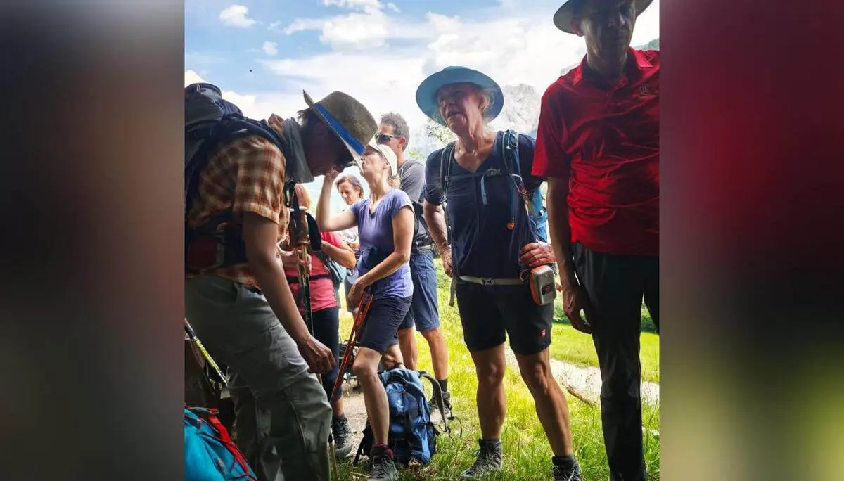Wandergruppe steht während einer Pause im Schatten eines Baumes am Bergweg; Rucksäcke und Wanderstöcke sind sichtbar. | © DAV Markt Schwaben / Erwin Matzinger