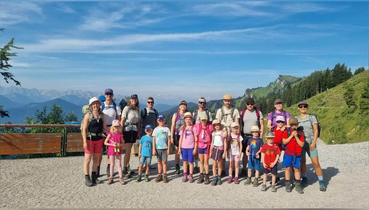 Große Wandergruppe mit Erwachsenen und Kindern auf einem Bergweg am Brauneck; dahinter Alpenpanorama und grüner Berghang. | © DAV Markt Schwaben