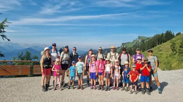 Große Wandergruppe mit Erwachsenen und Kindern auf einem Bergweg am Brauneck; dahinter Alpenpanorama und grüner Berghang. | © DAV Markt Schwaben