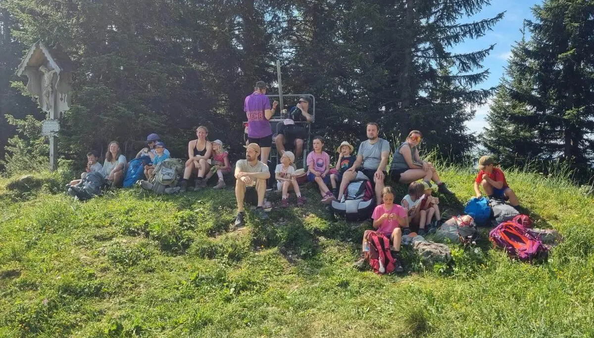 Wandergruppe mit Kindern und Erwachsenen macht auf einer Wiese am Waldrand Pause; Rucksäcke liegen neben dem Weg. | © DAV Markt Schwaben