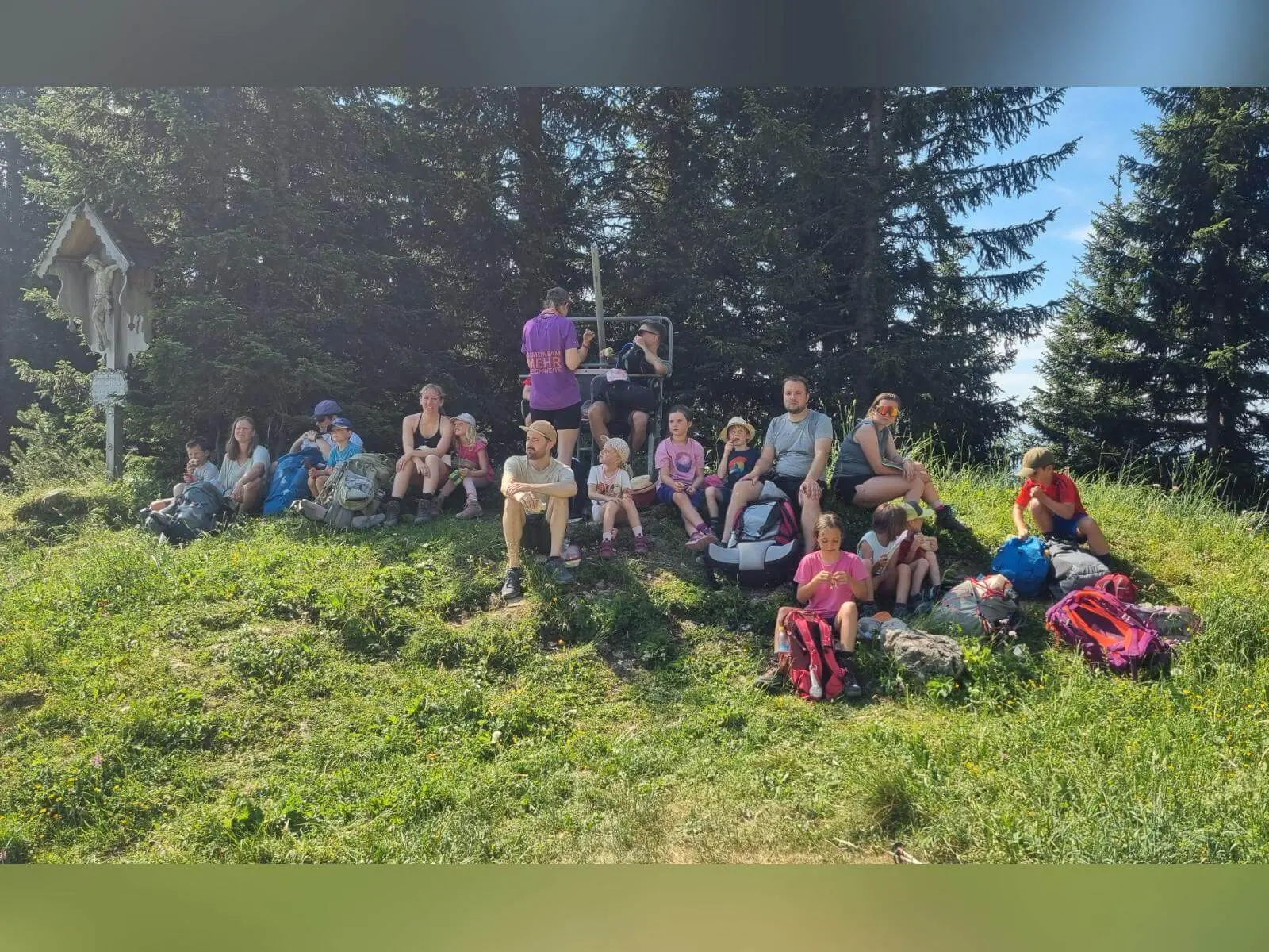 Wandergruppe mit Kindern und Erwachsenen macht auf einer Wiese am Waldrand Pause; Rucksäcke liegen neben dem Weg. | © DAV Markt Schwaben