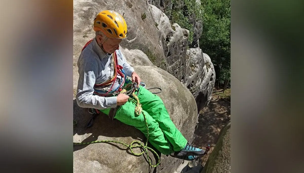 Eine Person mit Kletterhelm sitzt auf einem Sandsteinfels und ordnet das Seil. Unterhalb fällt die Felswand steil in eine schmale Schlucht ab. | © DAV Markt Schwaben/Erwin&Ursula Matzinger