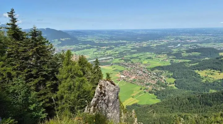 Blick von einem felsigen Aussichtspunkt über das Inntal mit Wäldern, Feldern und Ortschaften. Im Vordergrund stehen Felsen und Nadelbäume. | © DAV Markt Schwaben / Hubert Inhofer