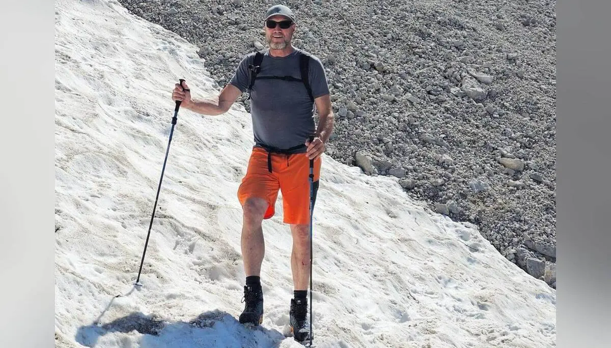 Eine Person überquert mit Wanderstöcken ein Schneefeld im steilen Kalkgelände. Daneben erstreckt sich eine graue Schutthalde aus Felsgeröll. | © DAV Markt Schwaben/Lutz Gründel