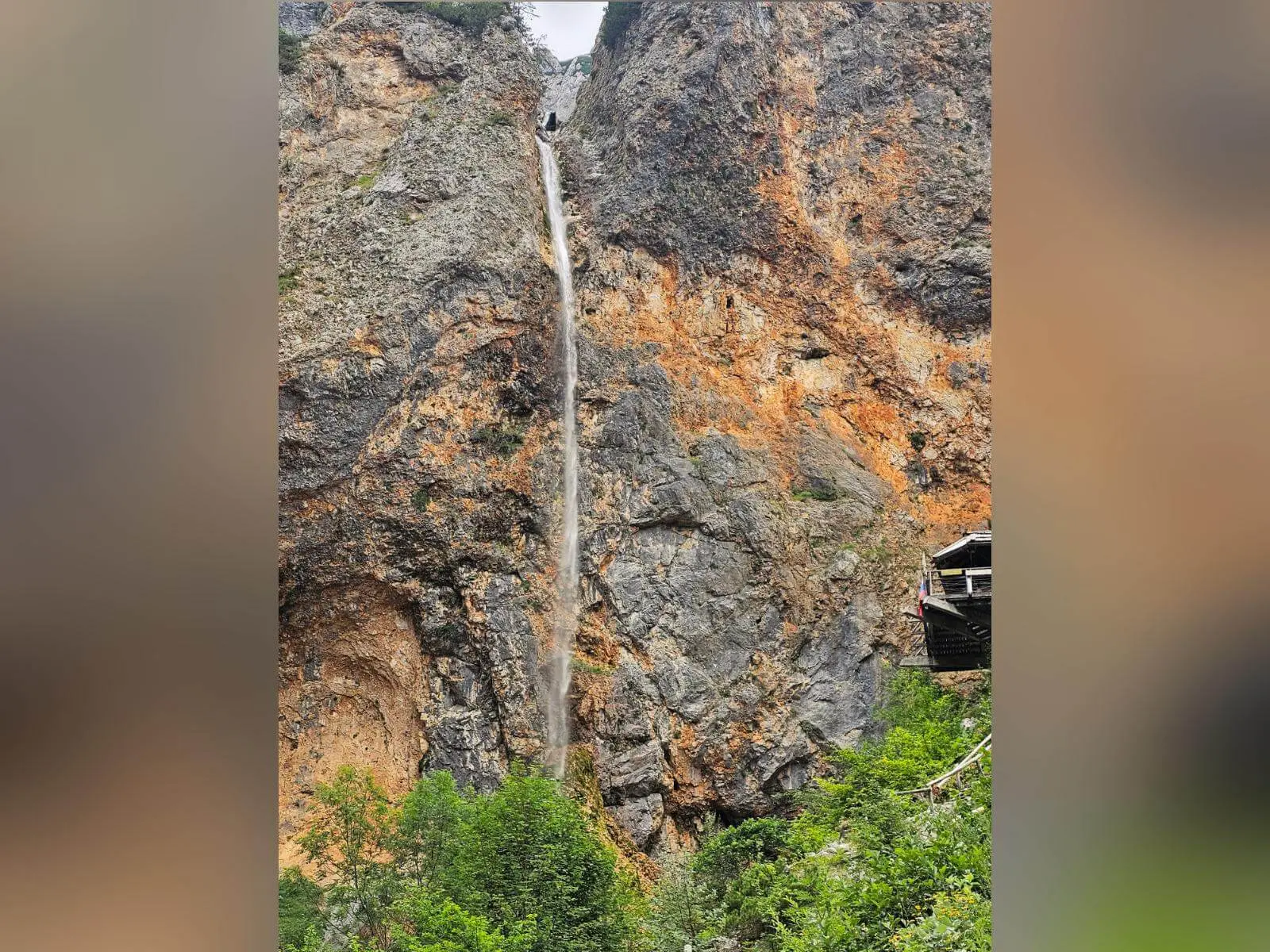 Der Rinka-Wasserfall stürzt als schmaler Wasserstrahl über eine hohe Felswand ins Tal. Rechts steht eine Aussichtsplattform am Felsen. | © DAV Markt Schwaben/Lutz Gründel