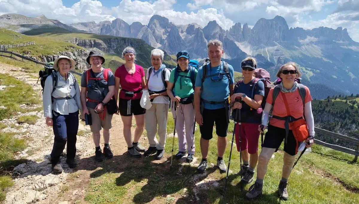 Acht Wandernde mit Rucksäcken und Stöcken stehen auf einem Höhenweg; dahinter ragen markante Dolomitengipfel auf. | © DAV Markt Schwaben/Gerlinde Hübl