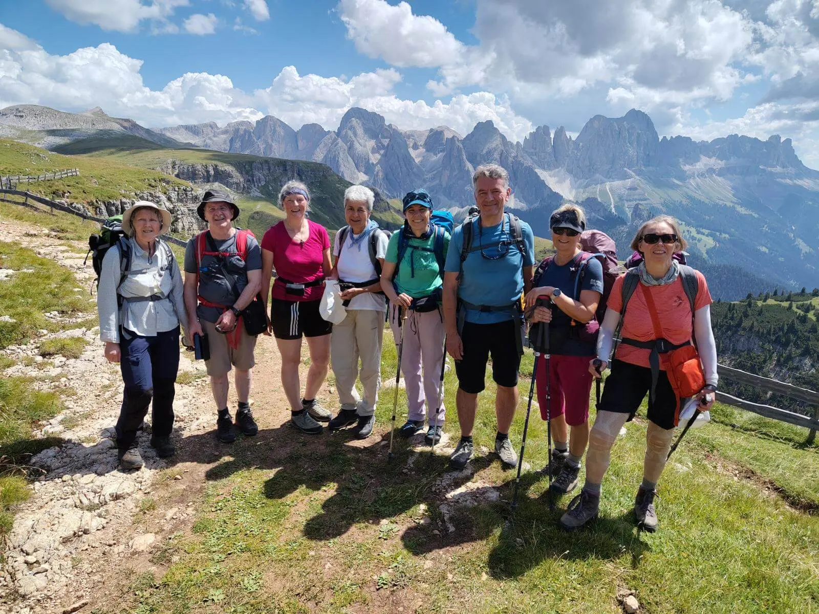 Acht Wandernde mit Rucksäcken und Stöcken stehen auf einem Höhenweg; dahinter ragen markante Dolomitengipfel auf. | © DAV Markt Schwaben/Gerlinde Hübl