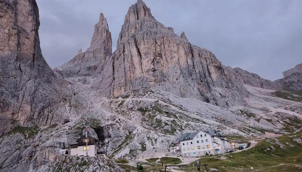 Berghütten liegen unter den steilen Felswänden der Vajolett-Türme; die Dolomiten zeigen sich in der Abenddämmerung. | © DAV Markt Schwaben/Gerlinde Hübl