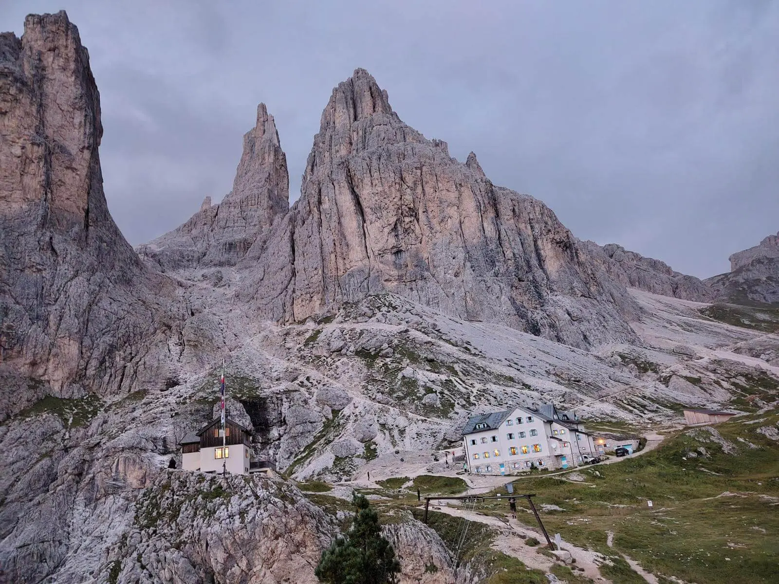 Berghütten liegen unter den steilen Felswänden der Vajolett-Türme; die Dolomiten zeigen sich in der Abenddämmerung. | © DAV Markt Schwaben/Gerlinde Hübl