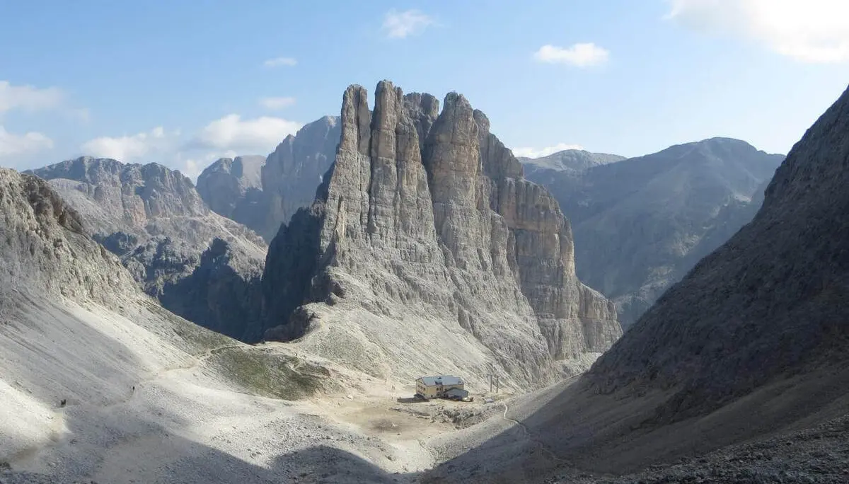Blick in ein felsiges Dolomitental mit markanten Vajolettürmen; am Talboden liegt eine Berghütte zwischen Geröllhängen. | © DAV Markt Schwaben/Gerlinde Hübl