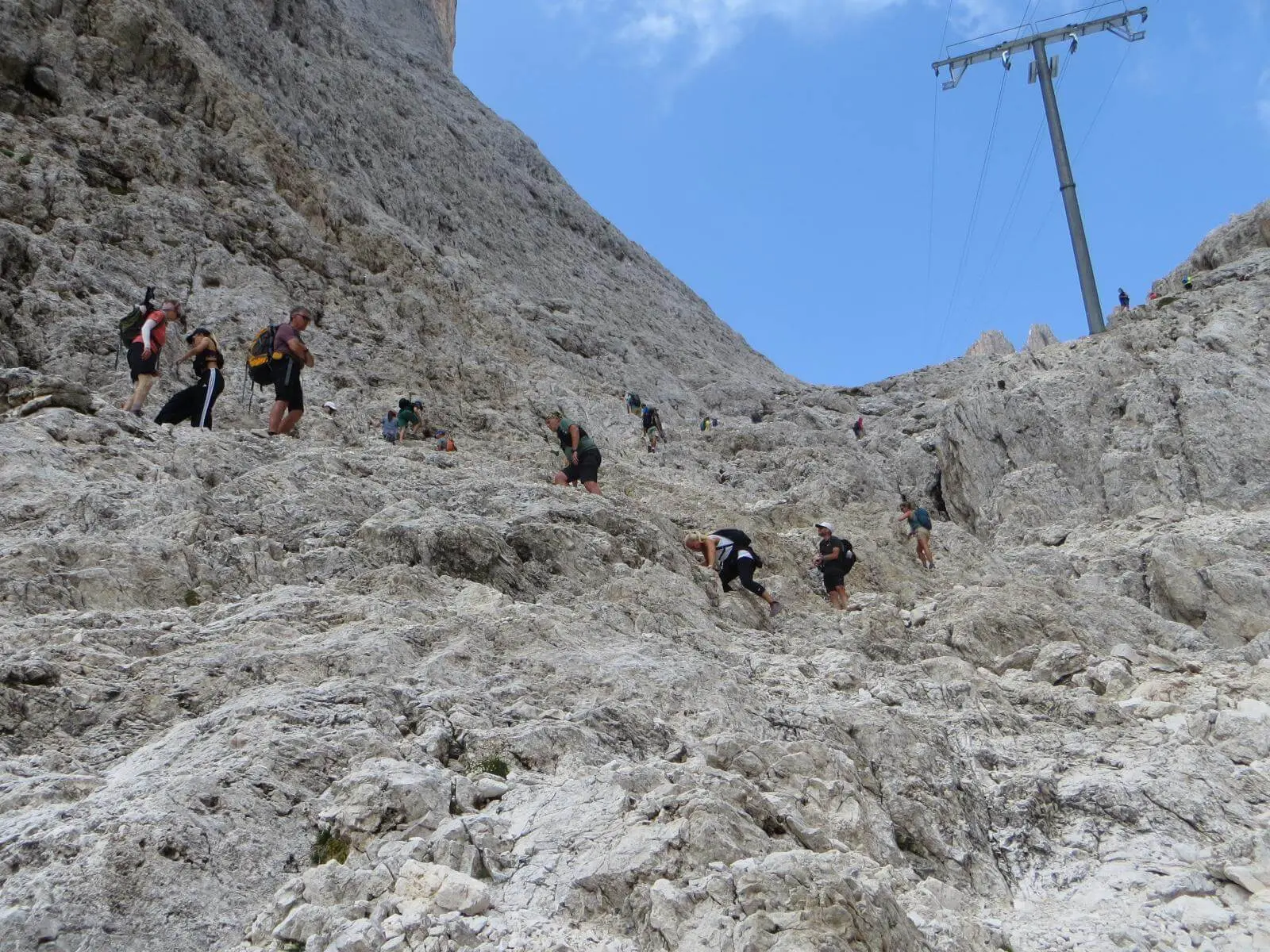 Zahlreiche Bergwandernde steigen durch steiles, felsiges Gelände zum Santnerpass auf; der Weg führt über hellen Kalkfels. | © DAV Markt Schwaben/Gerlinde Hübl