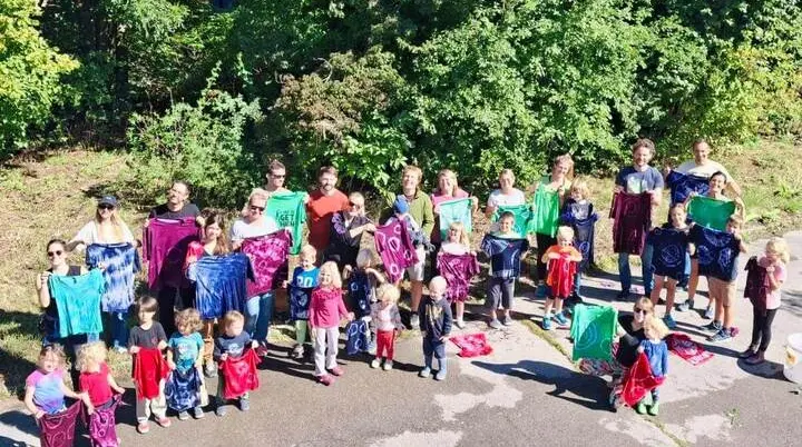 Familien und Kinder zeigen ihre selbst batikten T-Shirts und Stoffe. Die bunten Ergebnisse werden gemeinsam im Freien präsentiert. | © DAV Markt Schwaben / Lara Wolff