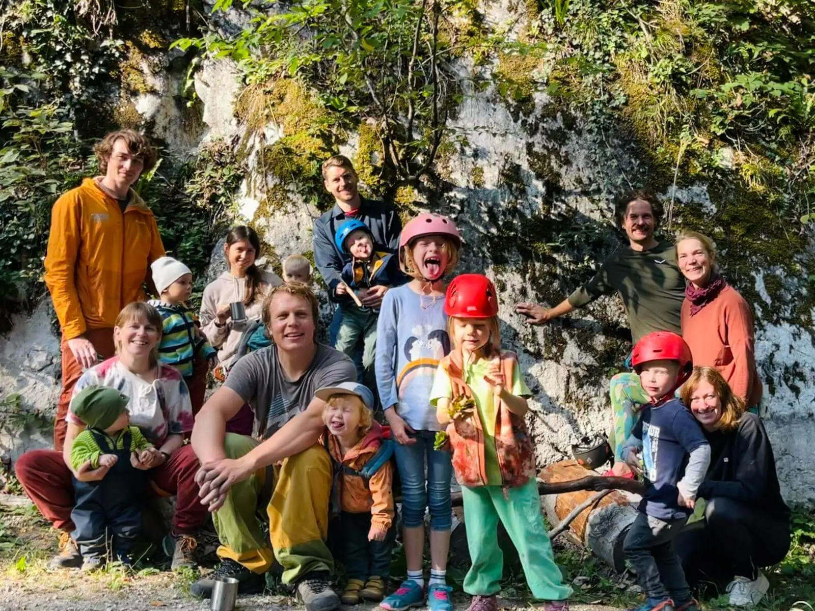 Familiengruppe mit Kindern in Kletterhelmen vor einer Felswand. Die Teilnehmenden machen am Klettergarten Auer Wandl Rast. | © DAV Markt Schwaben/Lara Wolff