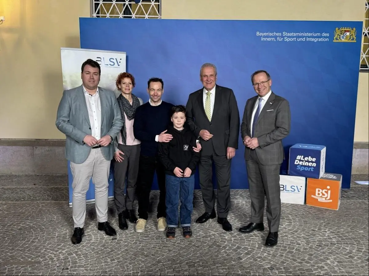 Sechs Personen stehen vor blauem Hintergrund mit Logos des bayerischen Innenministeriums und Sportverbänden; sie posieren für ein offizielles Foto. | © BLSV/​Hermann