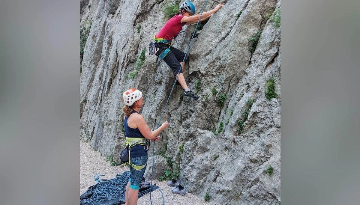 Eine Person klettert am Fels, die andere sichert vom Boden aus; Seil und Ausrüstung gut sichtbar. | © DAV Markt Schwaben | Foto Lutz Gründel