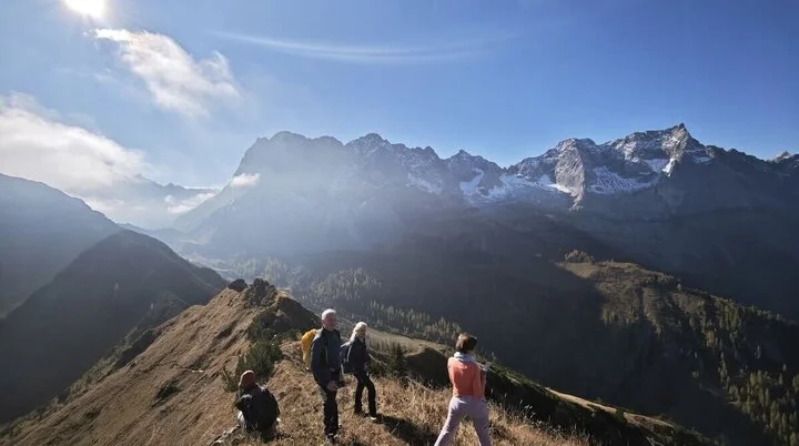 Rast mit Aussicht am Gramaijoch | © DAV Markt Schwaben · Foto: Matzinger Vier Wandernde auf einem Bergrücken mit Blick auf schneebedeckte Gipfel; sonnige Lichtstimmung und klare Fernsicht. | © DAV Markt Schwaben · Foto: Matzinger