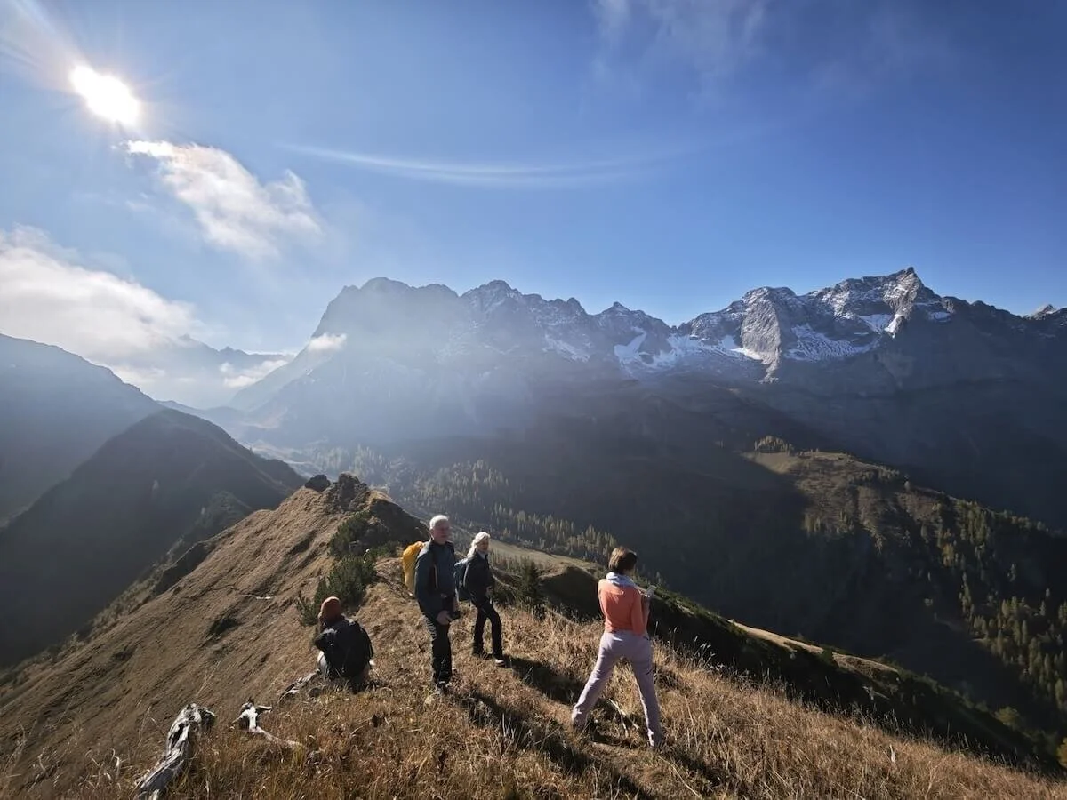 Vier Wandernde auf einem Bergrücken mit Blick auf schneebedeckte Gipfel; sonnige Lichtstimmung und klare Fernsicht. | © DAV Markt Schwaben · Foto: Matzinger