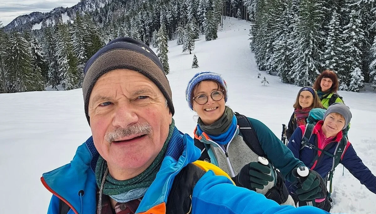 Fünf Wandernde posieren für ein Selfie im Schnee; im Hintergrund verschneite Tannen und Berge unter blauem Himmel. | © DAV Markt Schwaben | Foto: Lutz Gründel