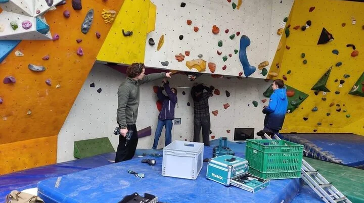 Vier Mitglieder reinigen den Bouldertempel, während sie Werkzeuge und Materialien im Einsatz haben. | © DAV Markt Schwaben