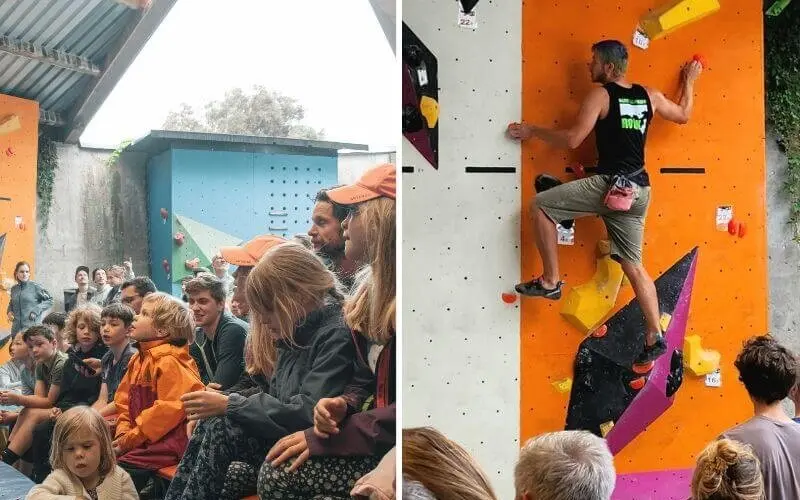 Erwachsene und Kinder verfolgen gespannt einen Kletterwettkampf, während ein Athlet die Boulderwand erklimmt. | © DAV Markt Schwaben | Foto: David Sigl & Anna Thoms