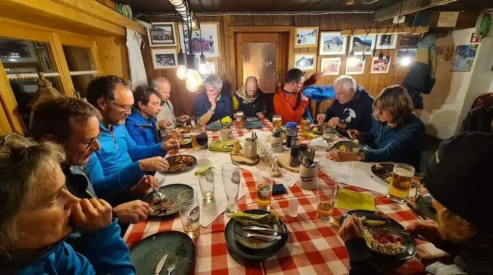 Gemeinsames Abendessen in einer Berghütte – Mitglieder des Alpenvereins genießen ein geselliges Event in winterlicher Atmosphäre. | © DAV Markt Schwaben · Foto: Tanja Döhler