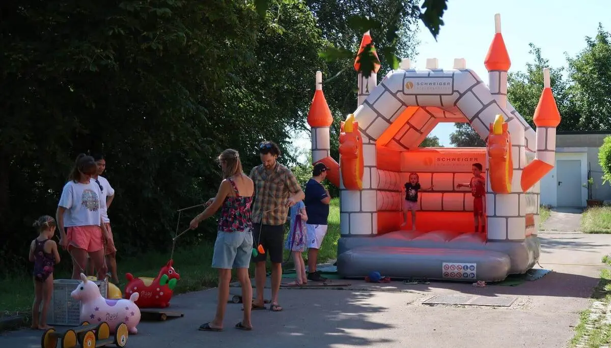 Kinder spielen an einer Hüpfburg und mit Spielgeräten beim Sommerfest. | © DAV Markt Schwaben/Susanne Mayerl