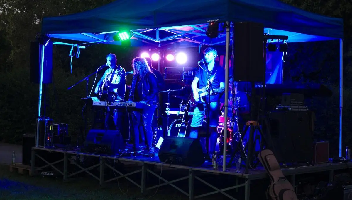 Zwei Helfer bereiten an der Grillstation Würstchen zu und geben sie an Besucher weiter. | © DAV Markt Schwaben/Thomas Schäffler