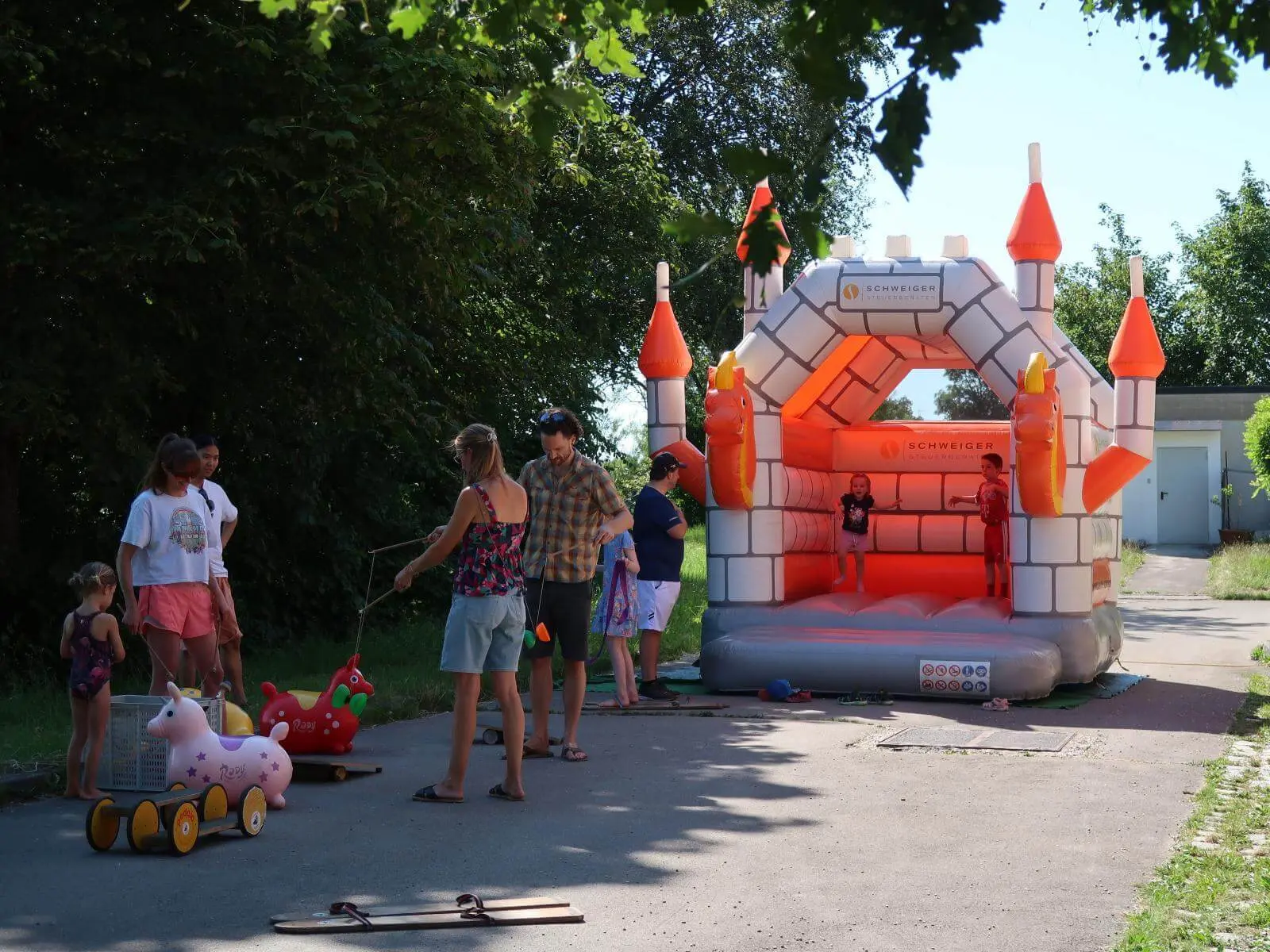 Kinder spielen an einer Hüpfburg und mit Spielgeräten beim Sommerfest. | © DAV Markt Schwaben/Susanne Mayerl