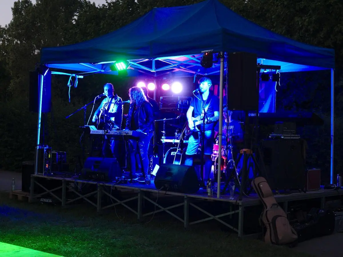 Zwei Helfer bereiten an der Grillstation Würstchen zu und geben sie an Besucher weiter. | © DAV Markt Schwaben/Thomas Schäffler