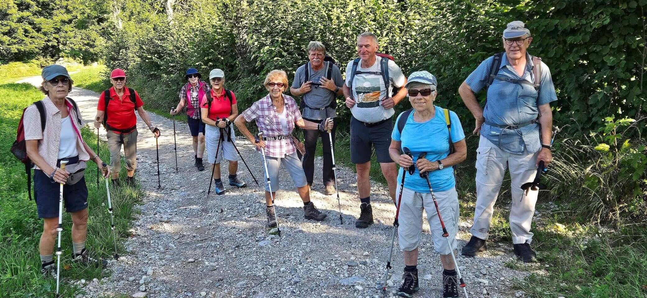 Eine Gruppe aktiver Seniorinnen und Senioren erkundet gemeinsam die Natur – ausgestattet mit Wanderrucksäcken und Trekkingstöcken genießen sie die Gemeinschaft auf einem idyllischen Waldweg. | © DAv Markt Schwaben | Foto: Hubert Inhofer