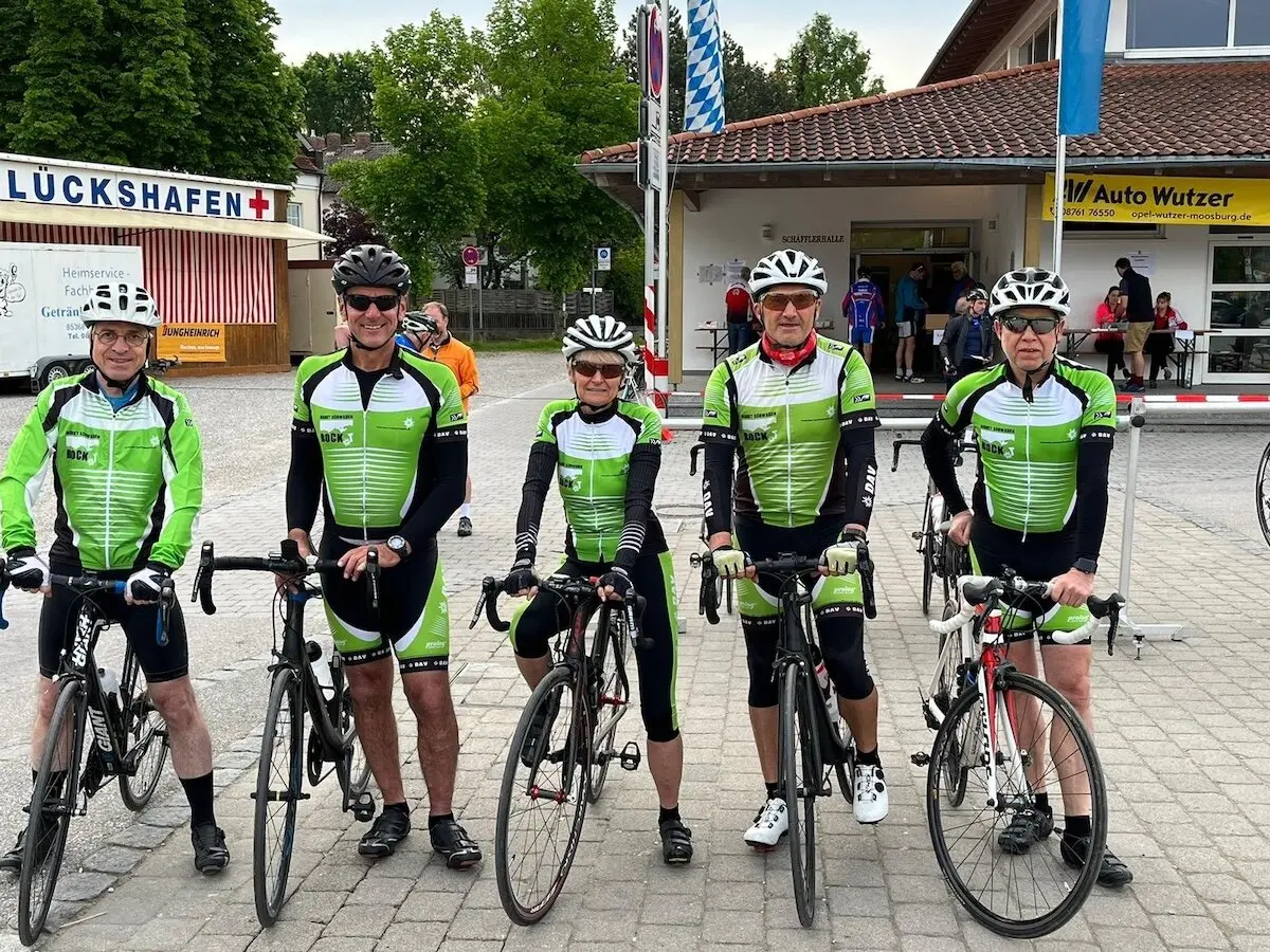 Fünf Radfahrer in einheitlicher Kleidung stehen mit ihren Rädern vor Gebäuden; Veranstaltungsszene im Freien. | © DAV Markt Schwaben