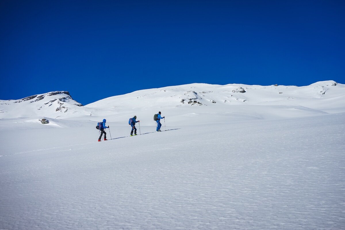 Skitour unter klarem blauen Himmel | © DAV Markt Schwaben | Foto Markus Sellmeier Drei Personen auf einer Skitour in einer schneebedeckten Landschaft unter klarem blauen Himmel. | © DAV Markt Schwaben | Foto Markus Sellmeier