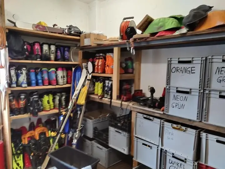 Materiallager mit Skischuhen, Ski, Helmen und beschrifteten Aufbewahrungsboxen in Regalen; ordentlich sortierte Ausrüstung. | © DAV Markt Schwaben