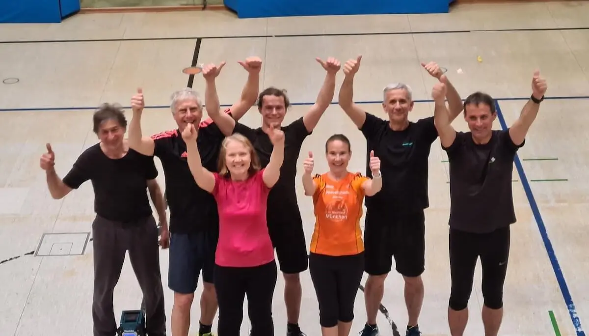 Sieben Erwachsene stehen in einer Sporthalle, lächeln in die Kamera und zeigen Daumen hoch nach dem Training. | © DAV Markt Schwaben