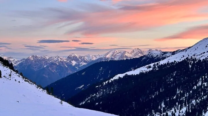 Drei Teilnehmer einer Skitourenausbildung stehen auf einer Schneedecke und sondieren mit Lawinensonden. Unter ihnen liegt eine Person in einer Schneehöhle, ausgerüstet mit Winterkleidung und Rucksack. Die Szene zeigt eine praktische Übung zur Verschüttetensuche im Rahmen der alpinen Ausbildung. | © DAV Markt Schwaben | Foto Markus Sellmeier